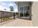 A concrete back porch has black railings, and sliding glass doors leading indoors, with a view of trees in the background at 817 E Mcdonald Ave, Eustis, FL 32726