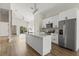 Spacious kitchen with island, stainless steel appliances, white cabinets, and light hardwood floors at 817 E Mcdonald Ave, Eustis, FL 32726