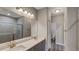 Bathroom featuring double sink vanity, large mirror, and glass-enclosed shower at 8584 Magnificent Ln, Groveland, FL 34736