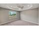 Bedroom featuring carpeted floor and a large window with a view of the surrounding area at 8584 Magnificent Ln, Groveland, FL 34736