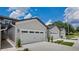 Close-up view of townhome exteriors, highlighting the attached garages and well-maintained landscaping at 8584 Magnificent Ln, Groveland, FL 34736