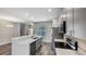Modern kitchen with gray cabinets, quartz countertop, stainless appliances, and open layout at 8584 Magnificent Ln, Groveland, FL 34736