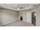 Spacious bedroom with tray ceiling, fan, and ensuite bathroom access at 8584 Magnificent Ln, Groveland, FL 34736