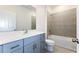 Bathroom with a combination shower-tub, a gray vanity, and tile floors for a sleek design at 9112 Wildlight Trl, Wildwood, FL 34785