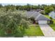 An aerial view of a well-maintained property with a large yard, mature trees, and a driveway leading to a two-car garage at 985 Willow Run Ln, Winter Springs, FL 32708