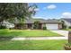 Charming single-story brick home with a well-manicured lawn, beautiful landscaping, and a two-car garage at 985 Willow Run Ln, Winter Springs, FL 32708