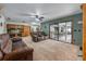 Spacious living room features carpet flooring, ceiling fan, and sliding glass doors to enclosed patio area at 985 Willow Run Ln, Winter Springs, FL 32708