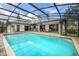 A beautiful screened-in pool area with chairs, patio, and outdoor kitchen bar at 985 Willow Run Ln, Winter Springs, FL 32708