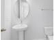 Clean and minimalist powder room featuring a pedestal sink and toilet at 10322 Marconi Ave, Orlando, FL 32827