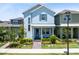Charming two-story home featuring a welcoming front porch, neat landscaping, and a vibrant blue facade at 10322 Marconi Ave, Orlando, FL 32827