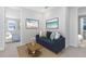 Cozy living area with a plush blue sofa, beach-themed art, and access to bedrooms for added convenience at 10322 Marconi Ave, Orlando, FL 32827