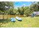 Waterfront backyard featuring two kayaks, lawn, and a blue Adirondack chair at 104 Yorktown Pl, Sanford, FL 32771