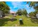The backyard boasts access to water, a fire pit, trees, and an umbrella table at 104 Yorktown Pl, Sanford, FL 32771
