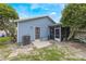 Exterior view of the backyard featuring a blue home, a patio, and an air conditioning unit at 104 Yorktown Pl, Sanford, FL 32771