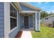 Home's inviting front entrance boasts light blue siding, white trim, house numbers, and small porch at 104 Yorktown Pl, Sanford, FL 32771