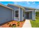 Inviting front entrance of home with light blue siding, white trim, decorative landscaping, and tiled walkway at 104 Yorktown Pl, Sanford, FL 32771