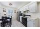 Functional kitchen with white cabinetry, a stainless steel refrigerator, and an adjacent breakfast nook at 104 Yorktown Pl, Sanford, FL 32771