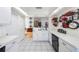 Functional kitchen with white cabinets, black appliances, tile floors, and easy access to other rooms at 104 Yorktown Pl, Sanford, FL 32771