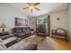 Cozy living room featuring a ceiling fan, comfortable seating, and natural light from a window at 104 Yorktown Pl, Sanford, FL 32771