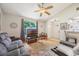 Inviting living room featuring a ceiling fan, a plush grey couch, and natural light from a window at 104 Yorktown Pl, Sanford, FL 32771