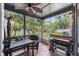 Outdoor screened porch featuring a ceiling fan, brick flooring, and a table with backyard view at 104 Yorktown Pl, Sanford, FL 32771