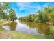 This yard features water access, lush greenery, and mature trees at 104 Yorktown Pl, Sanford, FL 32771