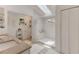 Well-lit bathroom with a skylight, dual sinks, walk-in shower, and modern fixtures at 109 Hunter Point Ct, Debary, FL 32713