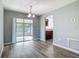 Dining area featuring a sliding glass door leading to the patio, complemented by stylish wood-look flooring and modern lighting at 1276 Comerwood Dr, Deltona, FL 32738