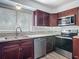 Close-up of the kitchen with wood cabinets, stainless appliances, and granite countertops at 1276 Comerwood Dr, Deltona, FL 32738
