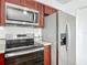 Close up of stainless microwave, refrigerator, and electric cooktop at 1276 Comerwood Dr, Deltona, FL 32738