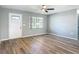 Well-lit living room showcasing wood-look flooring, a new white front door and ample natural light from a window at 1276 Comerwood Dr, Deltona, FL 32738