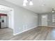 Living area with a stainless steel refrigerator, wood-look floors, offering a seamless flow into the kitchen at 1276 Comerwood Dr, Deltona, FL 32738