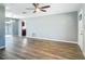 Open-concept living room with wood-look floors, showcasing seamless transition to the kitchen and dining area at 1276 Comerwood Dr, Deltona, FL 32738