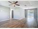 Spacious living room featuring modern wood-look flooring, ceiling fan, and access to the backyard through sliding glass doors at 1276 Comerwood Dr, Deltona, FL 32738