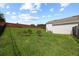 Large backyard with lush lawn, partial brick fence and young trees, offering privacy and space for outdoor activities at 1301 Johns Cove Ln, Oakland, FL 34787