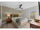 Inviting bedroom with stylish wall paneling, a ceiling fan, a window and a comfortable seating area at 1301 Johns Cove Ln, Oakland, FL 34787