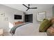 Well-lit bedroom features a mounted TV, ceiling fan, mirror, and comfortable furnishings at 1301 Johns Cove Ln, Oakland, FL 34787
