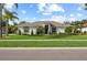 Single Gathering home exhibits a well-manicured lawn, complemented by palm trees and lush landscaping at 1301 Johns Cove Ln, Oakland, FL 34787