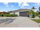 Two car garage features a well manicured lawn with meticulous landscaping at 1301 Johns Cove Ln, Oakland, FL 34787