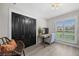 Well-lit office with wood-look floors, black closet and window offering a view of the outdoors at 1301 Johns Cove Ln, Oakland, FL 34787