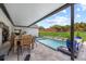 Outdoor covered pool with dining table and lounge chairs overlooking manicured lawn at 1301 Johns Cove Ln, Oakland, FL 34787