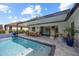 Inviting backyard featuring a sparkling pool, covered patio with dining, and lounge area, ideal for relaxation at 1301 Johns Cove Ln, Oakland, FL 34787