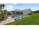 Expansive backyard featuring a sparkling pool, an outdoor dining area, and lush green lawn, perfect for entertaining at 1301 Johns Cove Ln, Oakland, FL 34787