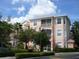 Condo exterior with balconies, manicured shrubs, and a view of a light colored three-story building at 13512 Turtle Marsh Loop # 729, Orlando, FL 32837