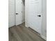 Hallway area with light gray wood-look floors and multiple white paneled doors at 13512 Turtle Marsh Loop # 729, Orlando, FL 32837