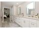 Bright bathroom featuring double vanities, granite countertops, and an open door into the main bedroom at 1364 Augusta National Blvd, Winter Springs, FL 32708