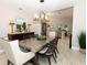 Open dining area with stainless steel table, dark wood chairs, and views to kitchen at 1364 Augusta National Blvd, Winter Springs, FL 32708