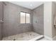 Elegant walk-in shower featuring gray tile, mosaic flooring, and a window at 1364 Augusta National Blvd, Winter Springs, FL 32708