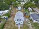 Aerial view of a two-story home with a large fenced backyard and additional storage buildings on the property at 1504 Indiana Ave, St Cloud, FL 34769