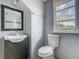 Bathroom with a vanity, toilet, mirror, and window with natural light and privacy at 1504 Indiana Ave, St Cloud, FL 34769